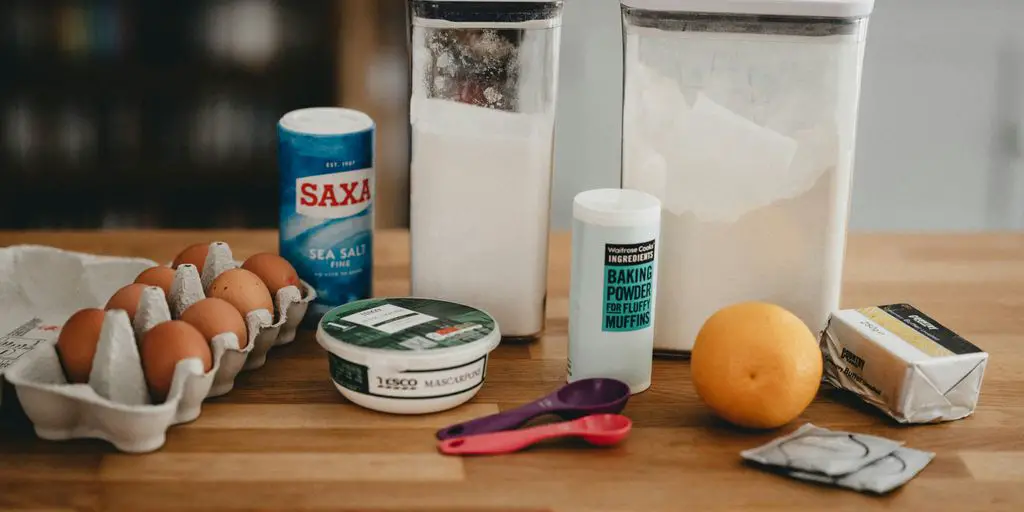 orange fruit beside white plastic bottle and red handled scissors